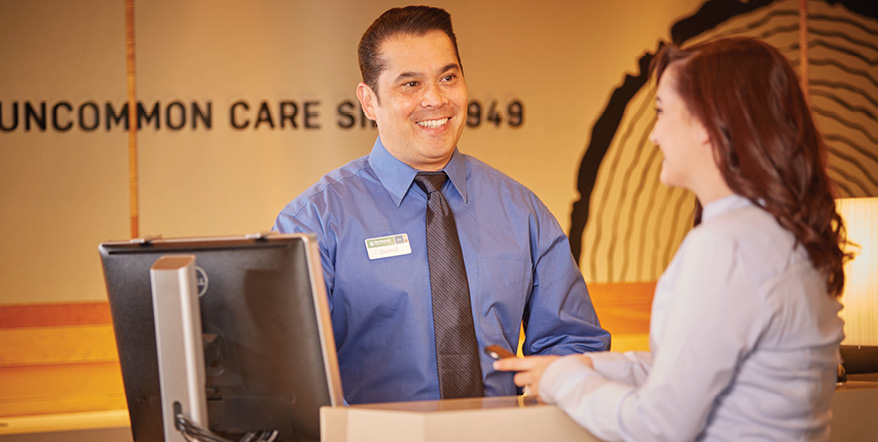 Image of smiling Illuminati Private Bank employee helping a member.